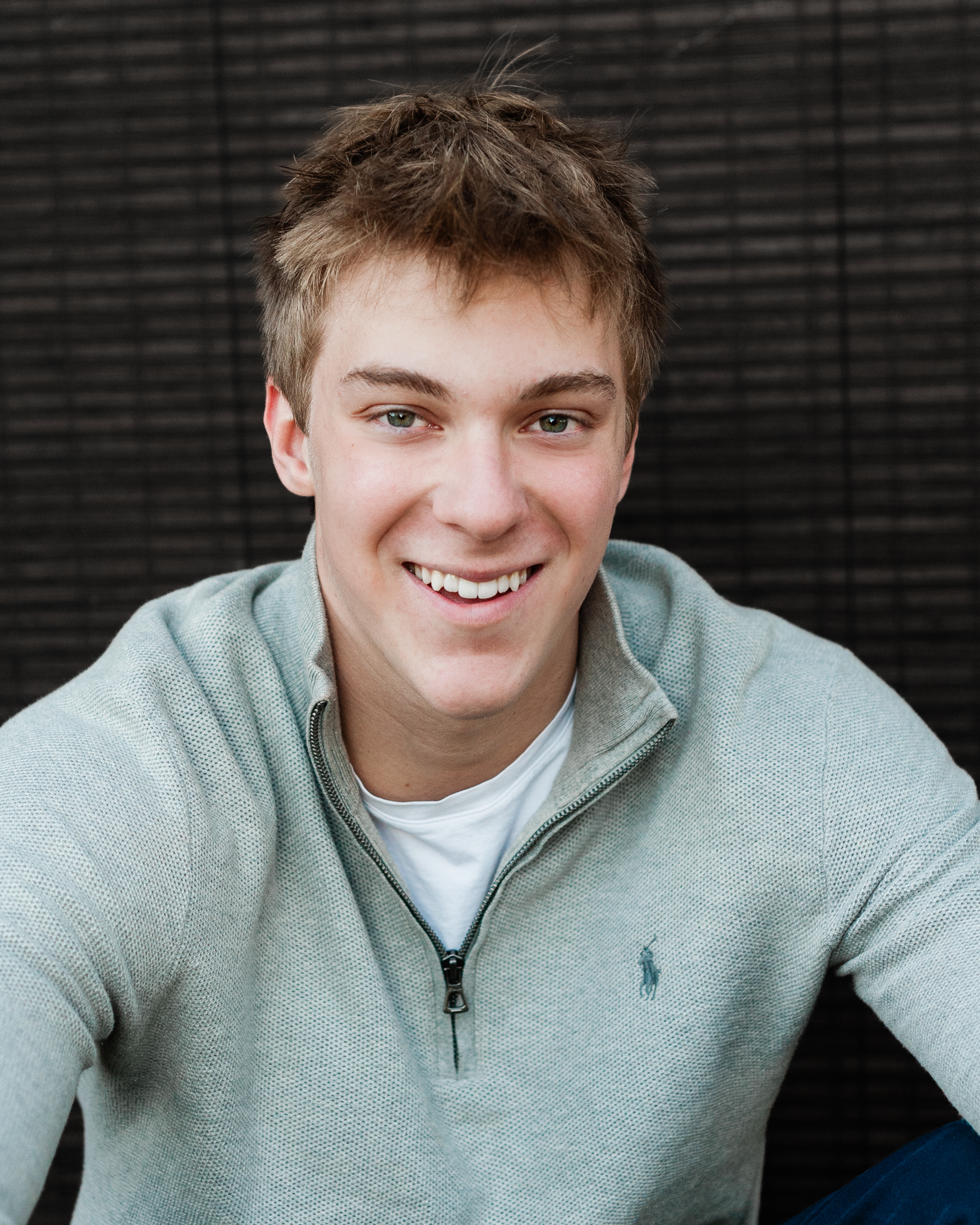 Jack Nielen smiling in a grey knit sweater